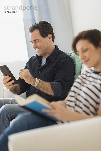 Couple sitting on sofa  man using digital tablet