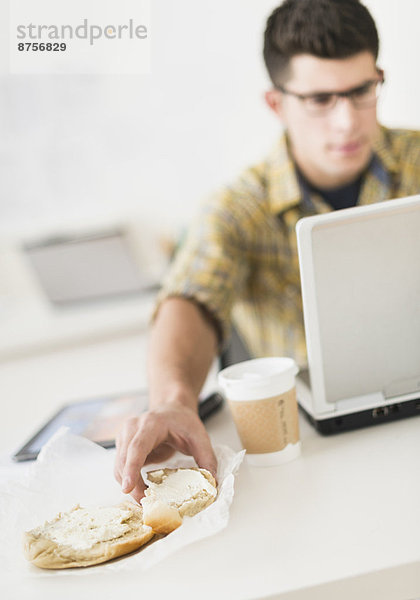 benutzen  Mann  Notebook  Sandwich  jung  essen  essend  isst