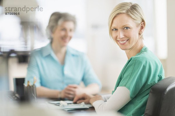 Portrait of female doctor  patient in background