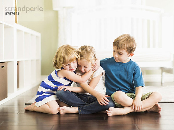 sitzend  Boden  Fußboden  Fußböden  umarmen  Junge - Person  5-9 Jahre  5 bis 9 Jahre