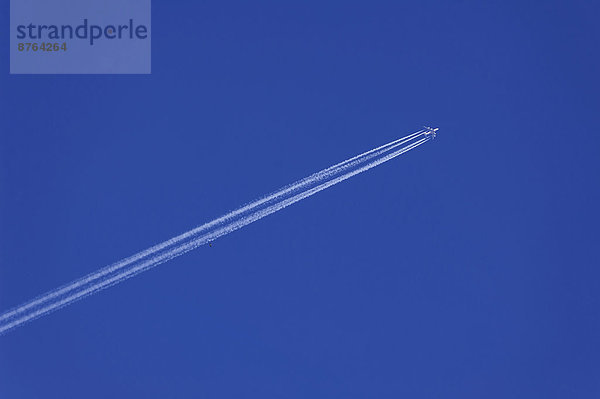 Flugzeug mit Kondensstreifen am blauen Himmel  Bayern  Deutschland
