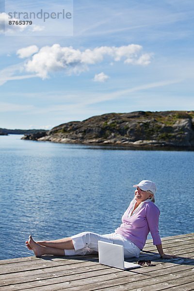 sitzend  Senior  Senioren  Frau  lächeln  Steg  Bohuslän  Schweden