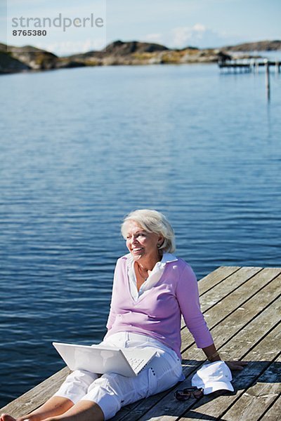 sitzend  Senior  Senioren  Frau  lächeln  Steg  Bohuslän  Schweden