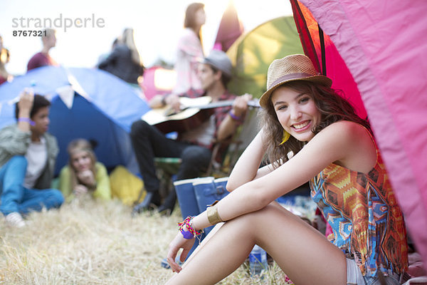 Porträt einer Frau  die beim Musikfestival vor dem Zelt sitzt.
