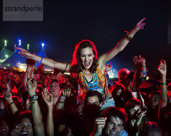 Jubelnde Frau auf den Schultern des Mannes beim Musikfestival