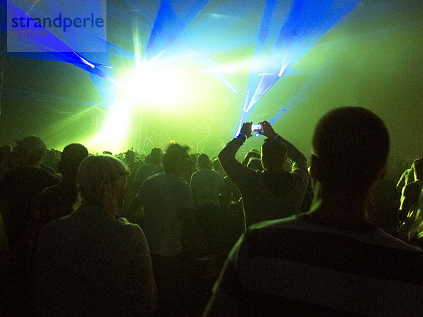 Silhouette der Menge vor der beleuchteten Bühne beim Musikfestival