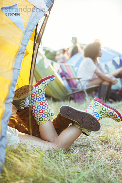 Paarbeine  die beim Musikfestival aus dem Zelt ragen