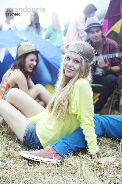 Porträt einer Frau  die beim Musikfestival mit Freunden vor den Zelten rumhängt.