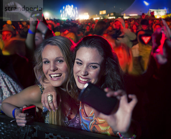 Freunde beim Selbstporträt mit Fotohandy beim Musikfestival