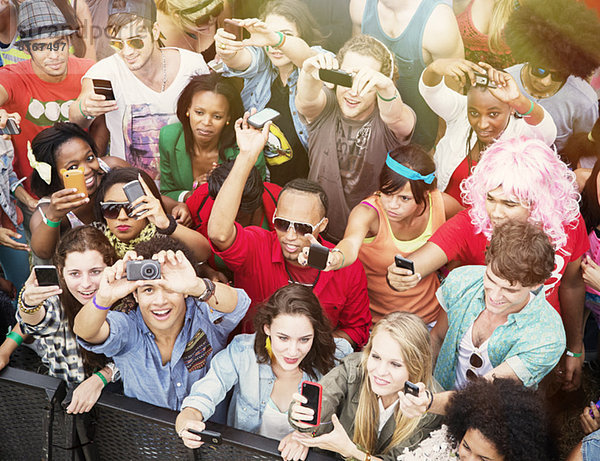 Fans mit Fotohandys jubeln beim Musikfestival