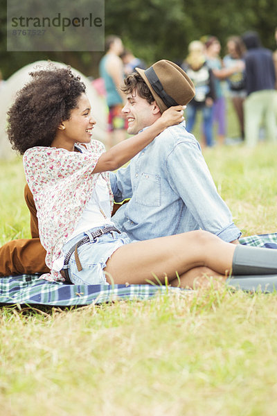 Paarumarmung auf der Decke im Gras beim Musikfestival