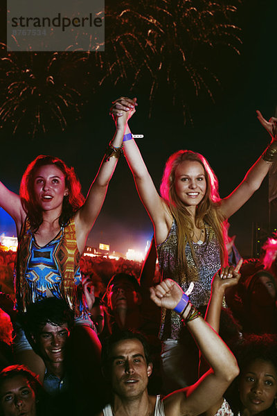 Jubelnde Frauen auf den Schultern der Männer beim Musikfestival