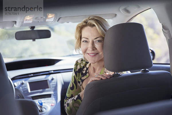 Porträt der glücklichen Seniorin im Auto