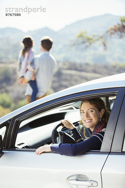 Porträt einer lächelnden Frau im Auto