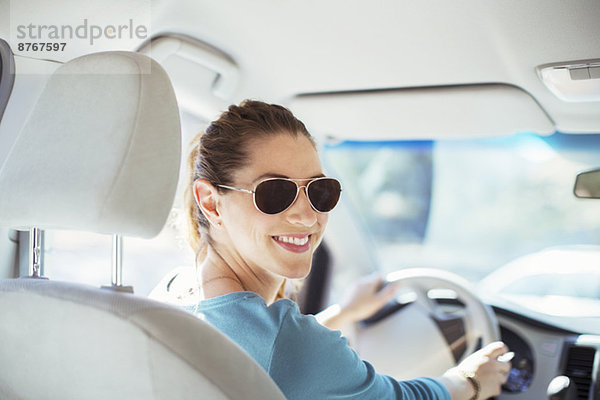 Porträt einer selbstbewussten Frau mit Sonnenbrille beim Autofahren