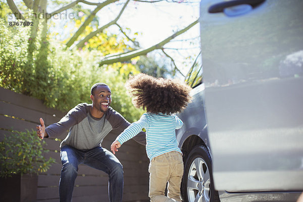 Enthusiastischer Vater begrüßt Tochter außerhalb des Autos