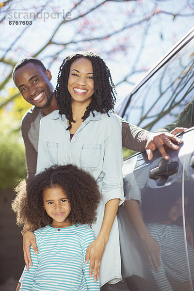 Porträt einer glücklichen Familie außerhalb des Autos