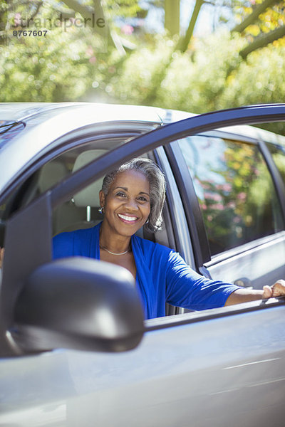 Porträt einer selbstbewussten Seniorin beim Aussteigen aus dem Auto