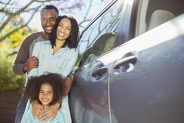 Porträt einer glücklichen Familie außerhalb des Autos