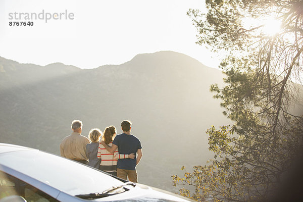 Familie mit Blick auf die Berge außerhalb des Autos