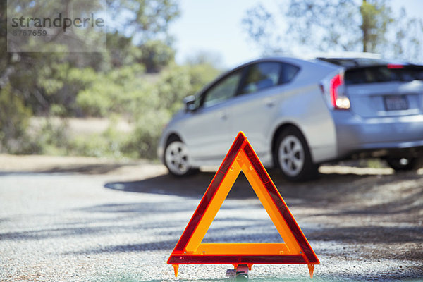 Auto am Straßenrand hinter Warndreieck