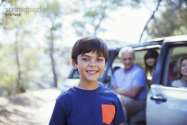 Porträt des lächelnden Jungen vor dem Auto