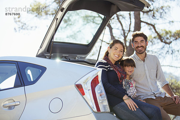 Porträt der glücklichen Familie am Heck des Autos