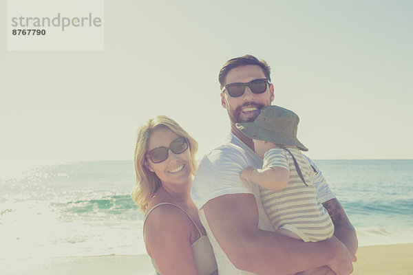 Porträt einer glücklichen Familie am sonnigen Strand
