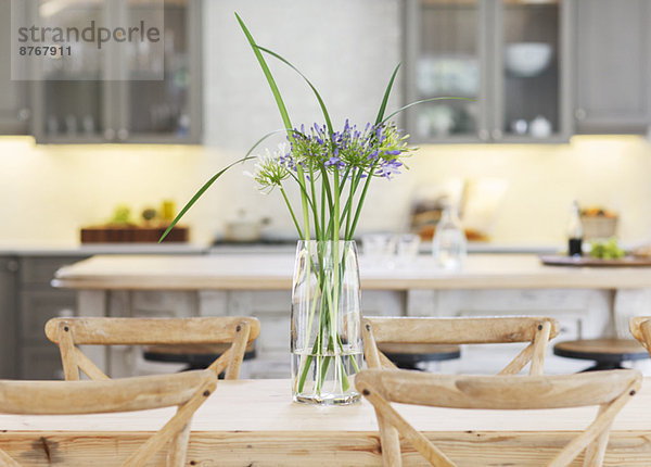 Blumen in Vase auf Holztisch