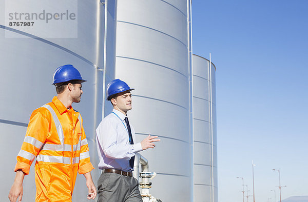 Geschäftsmann und Arbeiter in der Nähe von Silo-Lagertürmen