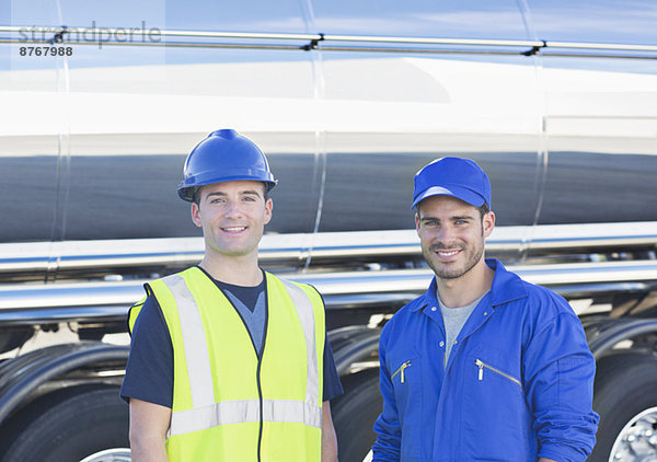 Porträt der selbstbewussten Arbeiter neben dem Edelstahltankwagen