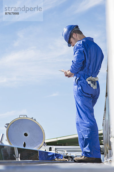 Arbeiter mit digitalem Tablett auf der Plattform