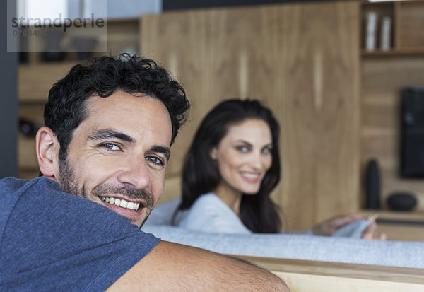 Porträt eines lächelnden Paares im Wohnzimmer