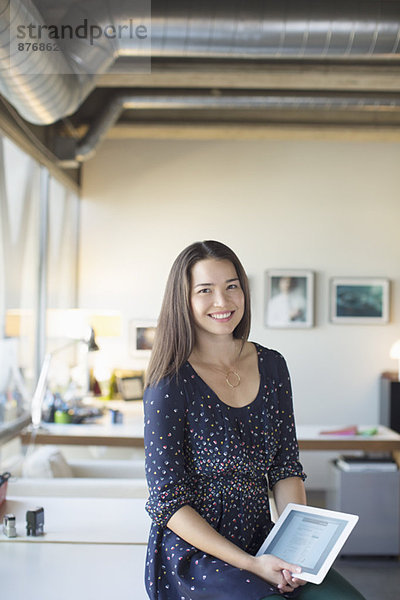 Porträt einer lächelnden Geschäftsfrau mit digitalem Tablett im Büro