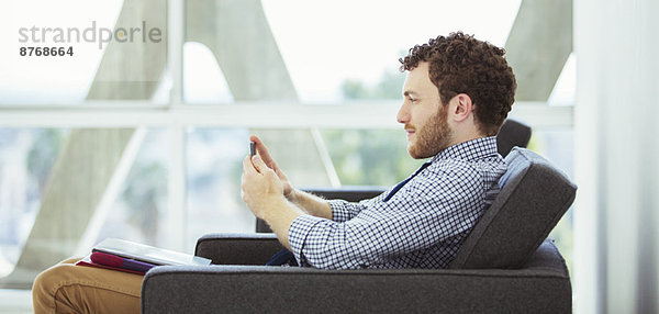 Geschäftsmann mit Handy in der Lobby