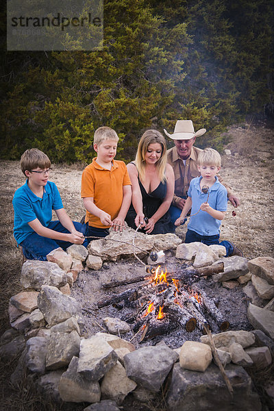 USA  Texas  Family Roasting marshmallows over camp fire
