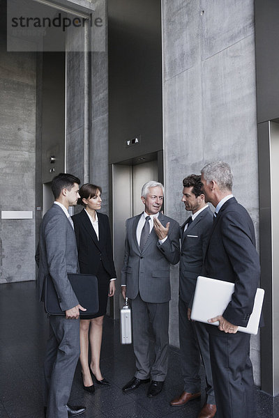 Group of businesspeople discussing at elevator