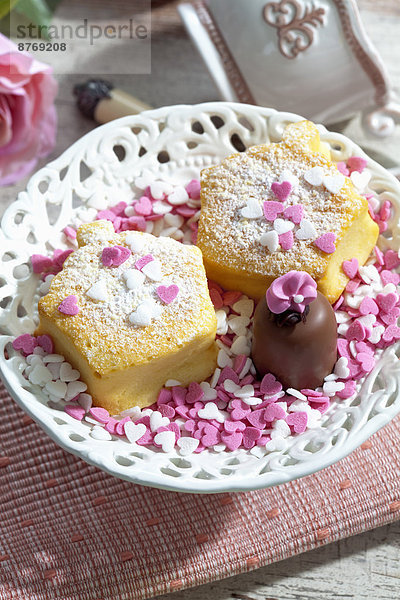 Zwei dekorierte Muffins  Schoko-Marshmallow und Zuckerherzen auf dem Teller