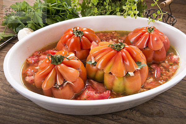 Filled beefsteak tomatoes in a gratin dish  raw  Low Carb