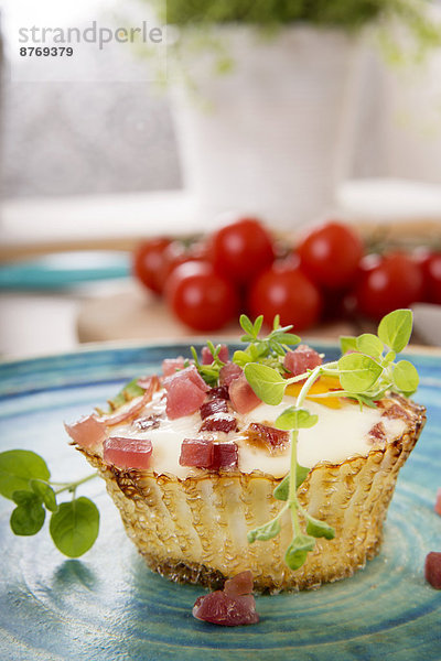 Egg muffin with ham cubes on plate