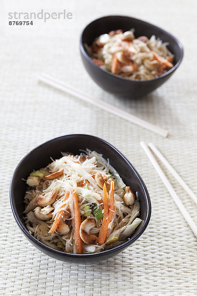 Wok dish with white cabbage  carrots  leek  egg and rice noodles