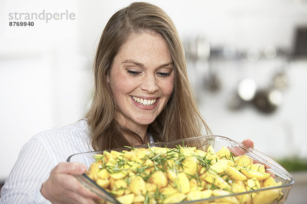 Frau bereitet Kartoffelgratin zu