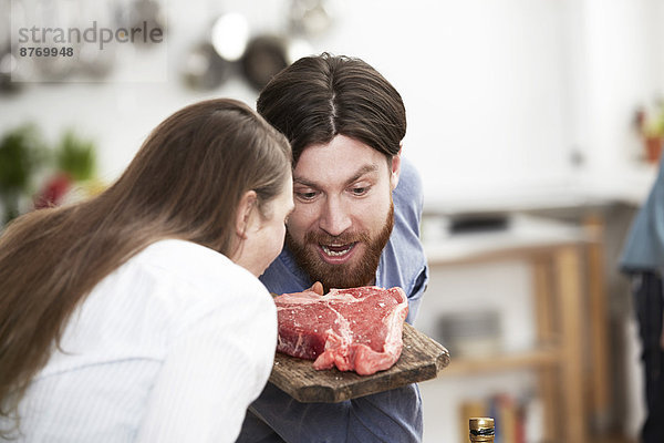 Mann und Frau in der Küche mit Blick auf das Steak