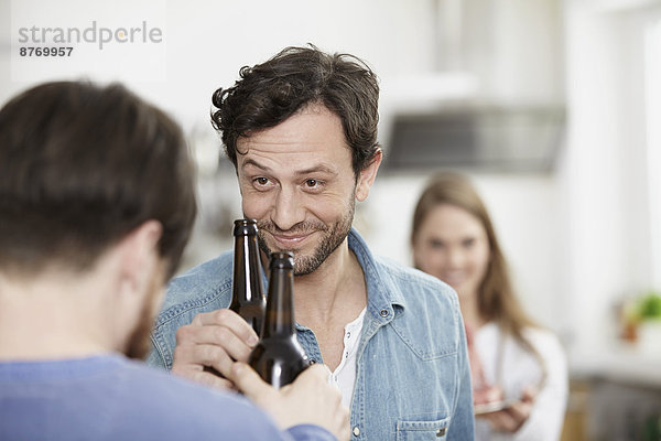 Friends in kitchen drinking beer