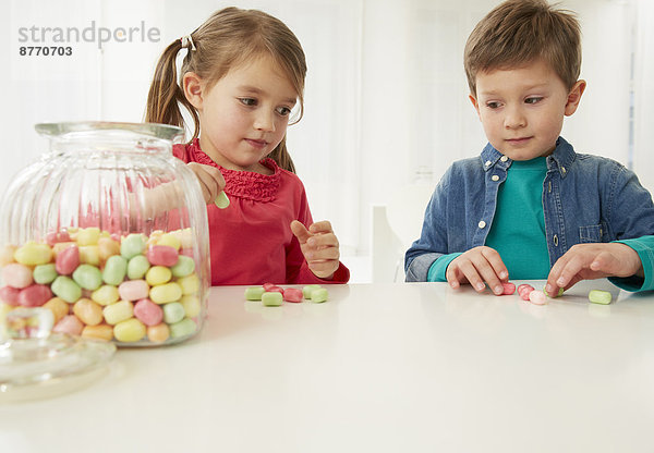 Junge und Mädchen mit Bonbonglas