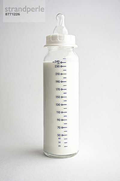 Babyflasche mit Milch vor weißem Hintergrund