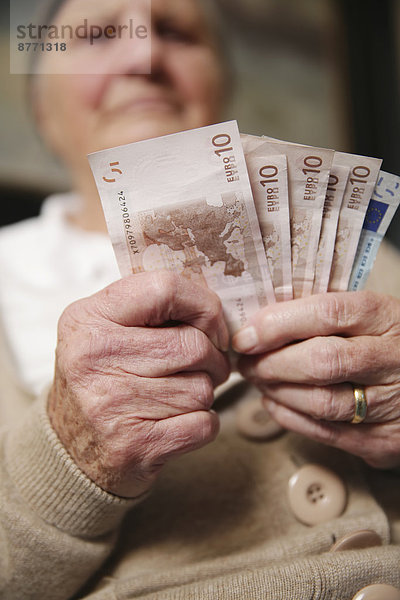 Seniorin mit Euro-Banknoten