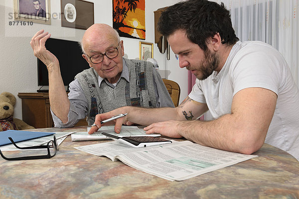 Enkel hilft seinem Großvater bei der Steuererklärung