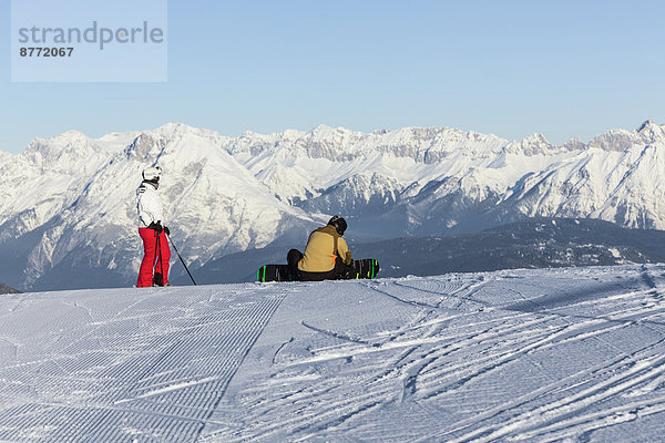 Austria  Tyrol  Innsbruck  Stubai Alps  view to Axamer Lizum with two skiers in front