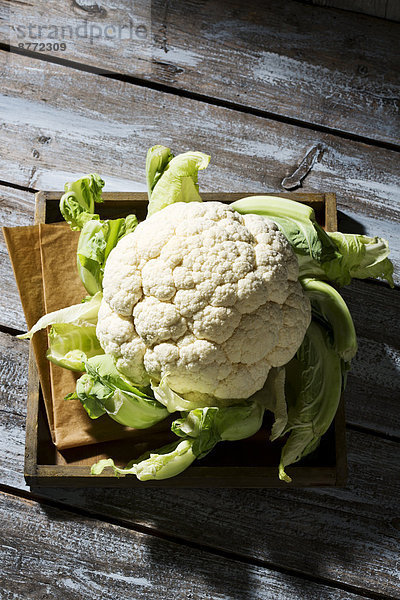 Cauliflower on wooden plate and table  view from above